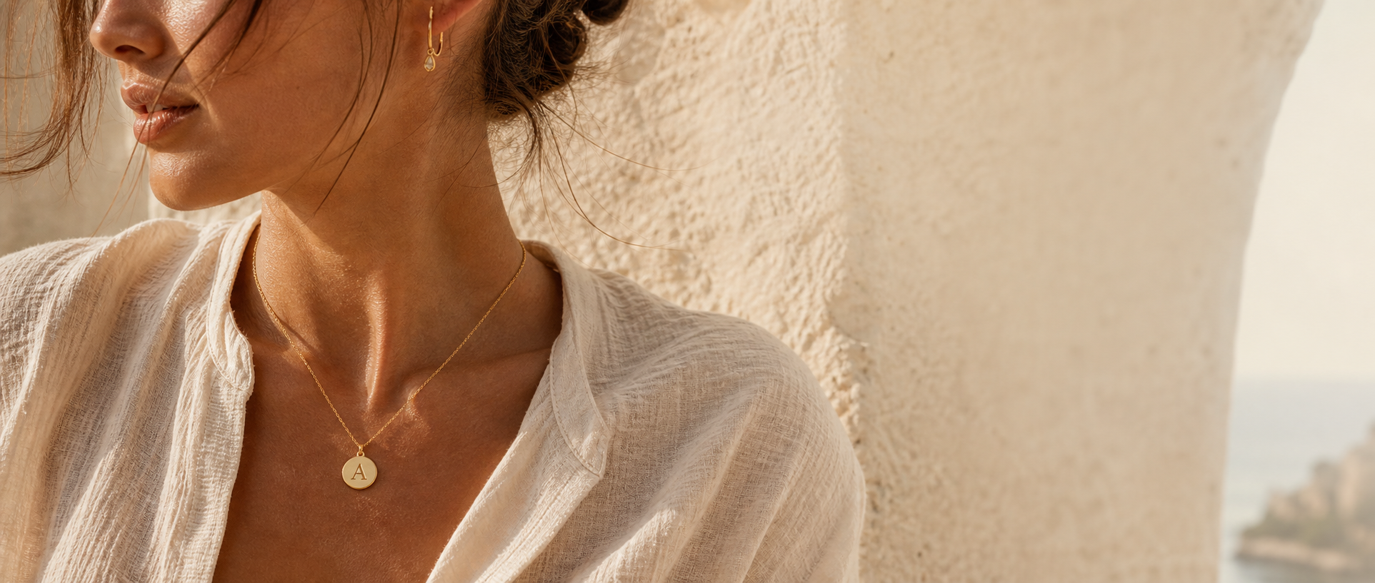 Woman wearing a personalised initial necklace in Mediterranean light